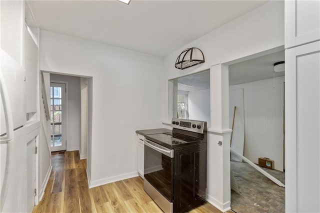 628 S Mulberry St, Ottawa, KS 66067 - kitchen featuring stainless steel range with electric stovetop, plenty of natural light, freestanding refrigerator, and light wood-style flooring