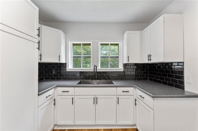 628 S Mulberry St, Ottawa, KS 66067 - kitchen featuring a sink, dark countertops, white cabinets, and backsplash