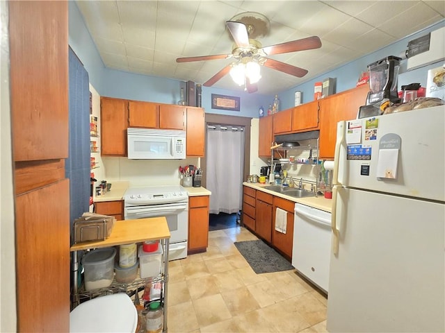 kitchen featuring a sink, ceiling fan, white appliances, and light countertops