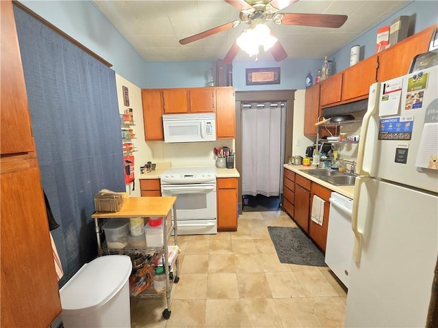 kitchen with a sink, white appliances, light countertops, brown cabinetry, and a ceiling fan
