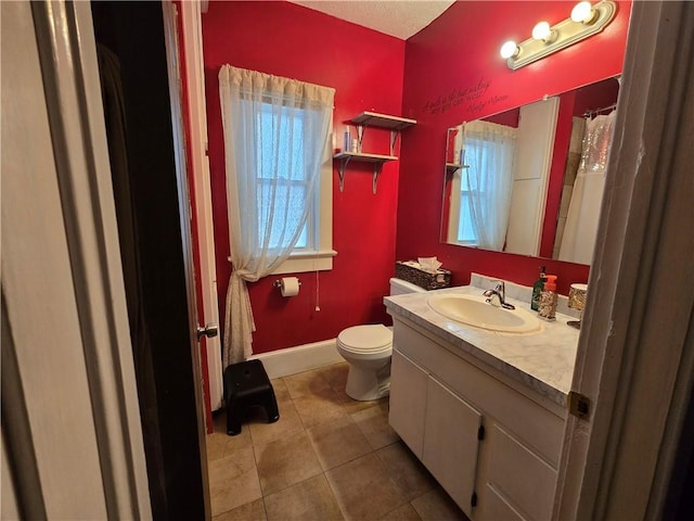 bathroom with tile patterned floors, baseboards, vanity, and toilet