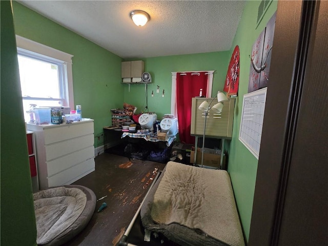 bedroom with a textured ceiling and wood finished floors
