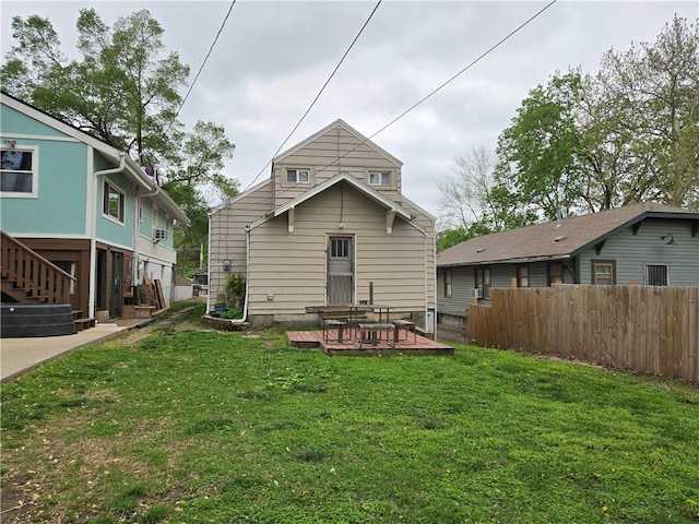 back of house with fence, a yard, and a deck