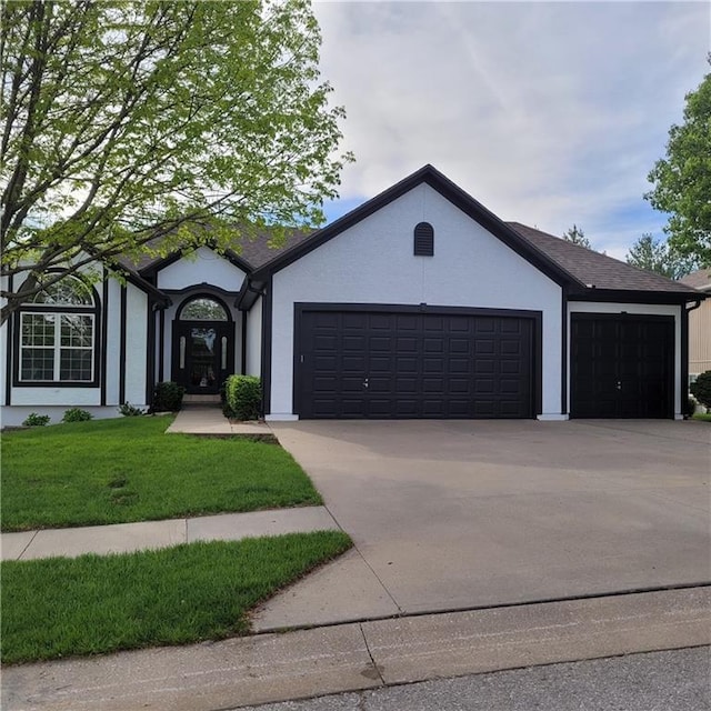 ranch-style home featuring stucco siding, driveway, a front yard, and a garage