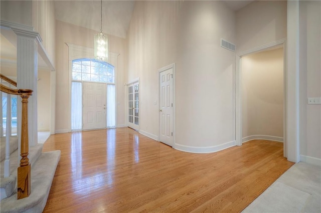 4411 N Mulberry Dr, Kansas City, MO 64116 - foyer featuring a notable chandelier, light wood-style floors, baseboards, a towering ceiling, and visible vents