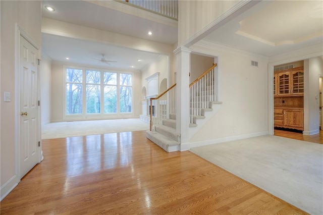4411 N Mulberry Dr, Kansas City, MO 64116 - carpeted entryway featuring a ceiling fan, crown molding, wood finished floors, baseboards, and stairs