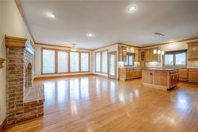 4411 N Mulberry Dr, Kansas City, MO 64116 - kitchen with crown molding, glass insert cabinets, brown cabinets, and light wood-type flooring