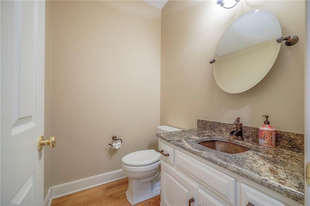 4411 N Mulberry Dr, Kansas City, MO 64116 - bathroom with toilet, baseboards, wood finished floors, and vanity