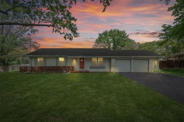view of front facade with fence, an attached garage, brick siding, aphalt driveway, and a front yard