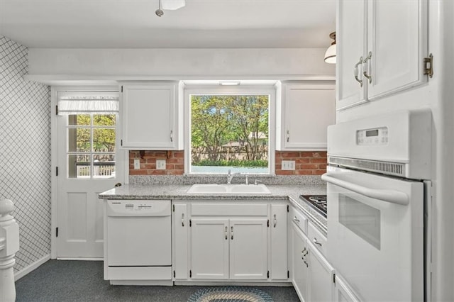 kitchen featuring a sink, white appliances, light countertops, white cabinetry, and tasteful backsplash