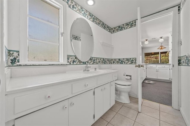 bathroom with vanity, tile patterned flooring, a wainscoted wall, and toilet