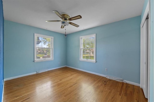unfurnished bedroom with baseboards, ceiling fan, a closet, and wood finished floors
