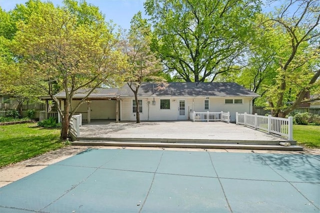 rear view of house featuring a lawn, a wooden deck, and fence