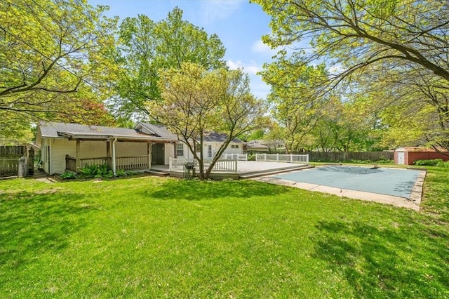 view of yard with a fenced backyard, a shed, an outbuilding, and a deck