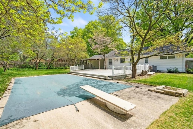 view of swimming pool featuring a wooden deck, a patio area, a fenced in pool, a fenced backyard, and a yard