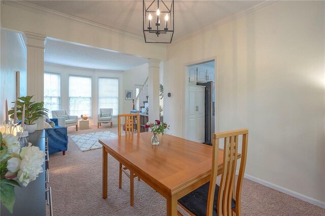 dining room with carpet floors, decorative columns, crown molding, and stairs