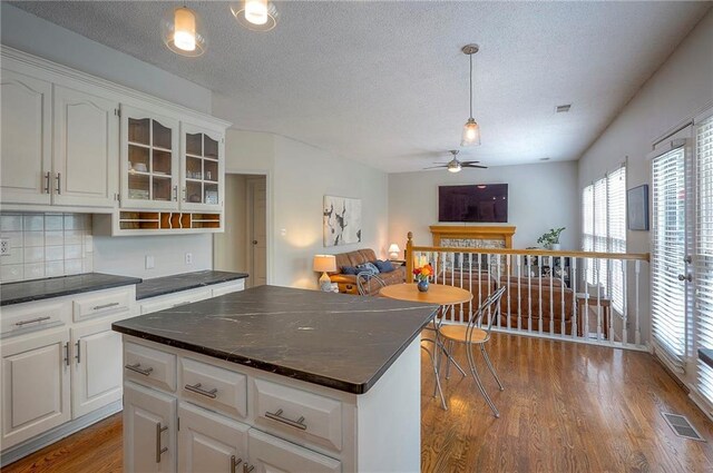 kitchen with a textured ceiling, ceiling fan, and dark countertops