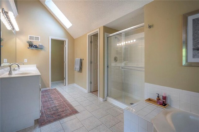 full bath with vaulted ceiling with skylight, tile patterned floors, a shower stall, visible vents, and a bath