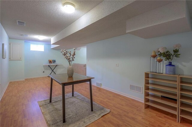 unfurnished office featuring wood finished floors and visible vents