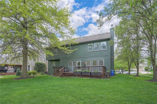 back of house with a yard, a wooden deck, and a chimney