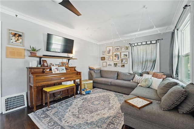living room featuring ceiling fan, visible vents, ornamental molding, and wood finished floors