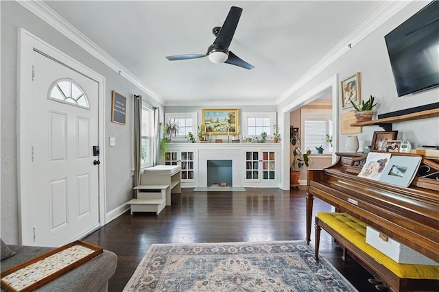 foyer entrance featuring ceiling fan, baseboards, ornamental molding, and wood finished floors