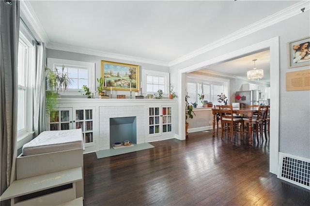 living area with visible vents, ornamental molding, wood finished floors, and plenty of natural light