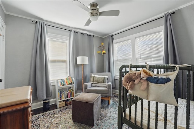 bedroom with baseboards, ornamental molding, multiple windows, and wood finished floors