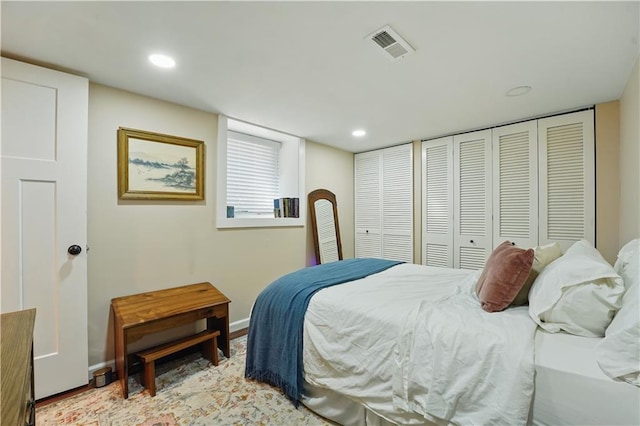 bedroom featuring visible vents, recessed lighting, baseboards, and multiple closets
