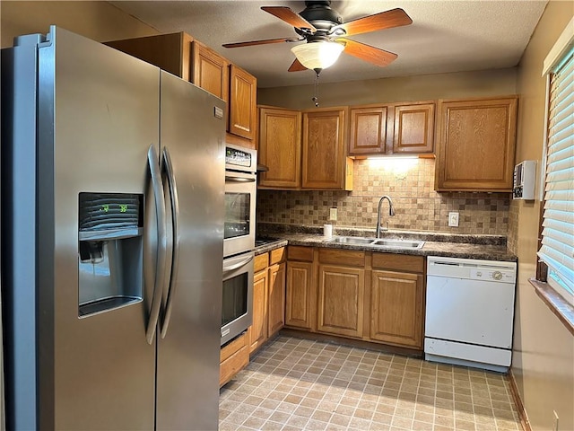 4322 Everett Ave, Kansas City, KS 66102 - kitchen featuring appliances with stainless steel finishes, a sink, dark countertops, and tasteful backsplash