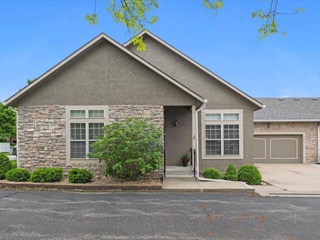 11179 S Summit St, Olathe, KS 66062 - view of front facade featuring a garage, stucco siding, stone siding, and concrete driveway
