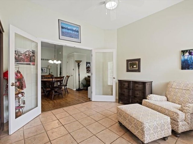 11179 S Summit St, Olathe, KS 66062 - living area featuring light tile patterned flooring, french doors, and ceiling fan with notable chandelier