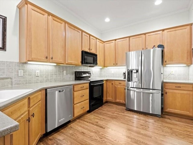 11179 S Summit St, Olathe, KS 66062 - kitchen featuring crown molding, decorative backsplash, light countertops, light wood-style flooring, and black appliances