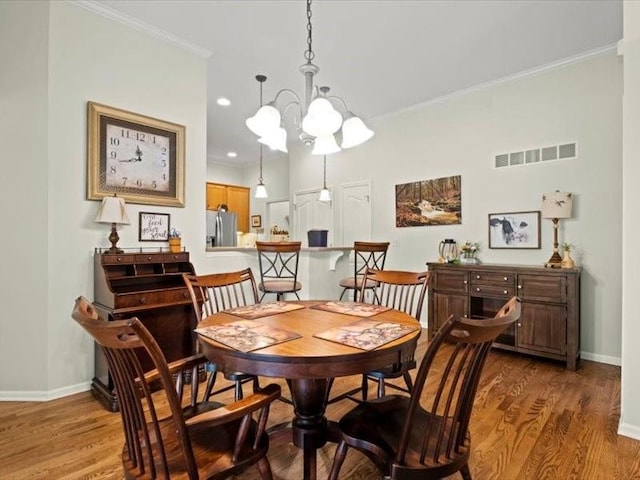 11179 S Summit St, Olathe, KS 66062 - dining room featuring visible vents, baseboards, wood finished floors, and a chandelier