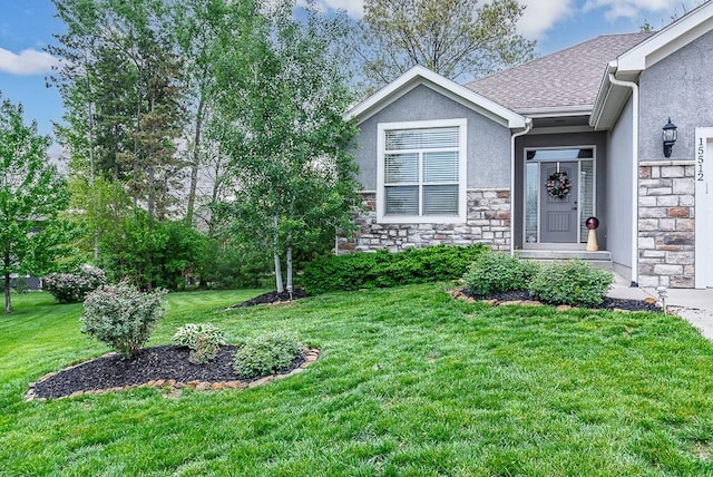 exterior space featuring a shingled roof, stucco siding, a front yard, and stone siding