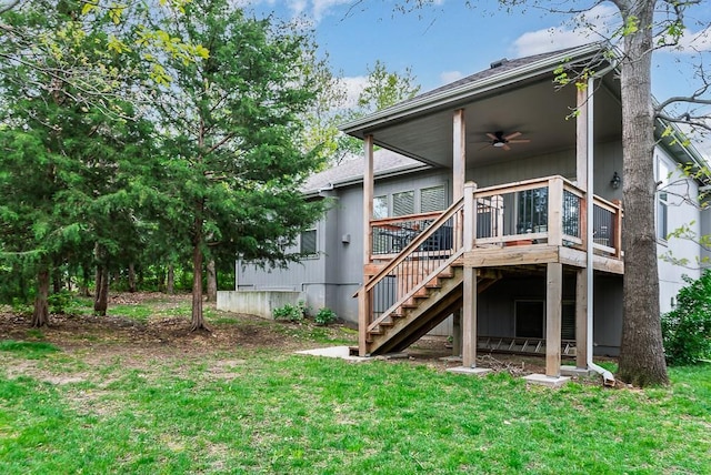 rear view of property with a ceiling fan, a deck, a yard, and stairway