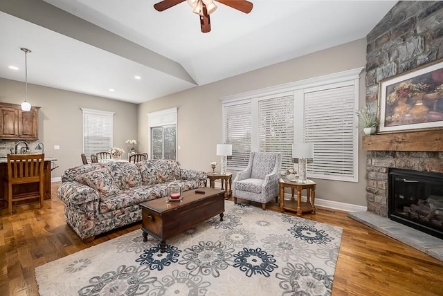 living area featuring ceiling fan, vaulted ceiling, wood finished floors, baseboards, and recessed lighting