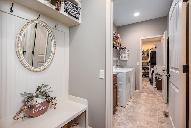 washroom with laundry area, baseboards, and washing machine and dryer