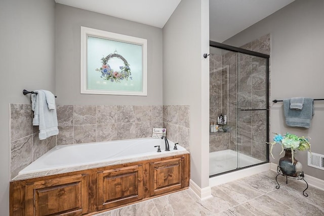 bathroom with visible vents, a shower stall, and a garden tub