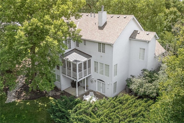 26266 W 110th Ter, Olathe, KS 66061 - back of property featuring a chimney, a sunroom, a patio, and roof with shingles