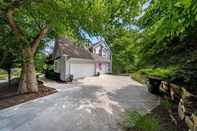 26266 W 110th Ter, Olathe, KS 66061 - view of home's exterior with driveway, an attached garage, roof with shingles, and a chimney