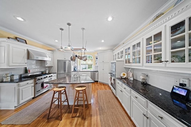 26266 W 110th Ter, Olathe, KS 66061 - kitchen with appliances with stainless steel finishes, crown molding, ventilation hood, a kitchen breakfast bar, and white cabinetry