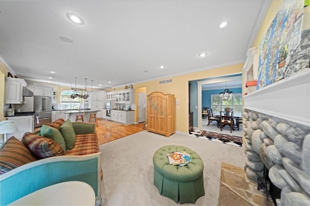 26266 W 110th Ter, Olathe, KS 66061 - living room featuring crown molding, recessed lighting, healthy amount of natural light, light wood finished floors, and a chandelier