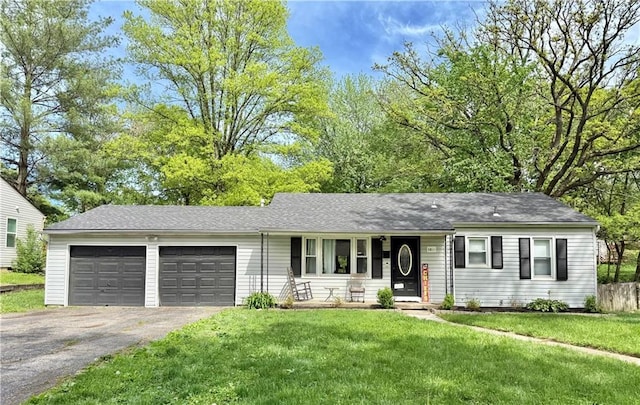5233 N Garfield Ave, Kansas City, MO 64118 - ranch-style home with driveway, an attached garage, a front lawn, covered porch, and a shingled roof