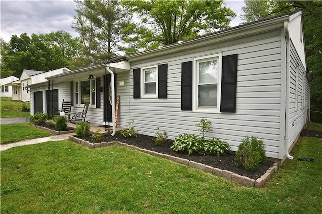 5233 N Garfield Ave, Kansas City, MO 64118 - ranch-style home featuring an attached garage, a front lawn, and a porch