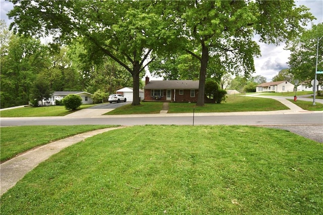 5233 N Garfield Ave, Kansas City, MO 64118 - view of front of home featuring a chimney, a front lawn, brick siding, and driveway