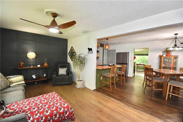5233 N Garfield Ave, Kansas City, MO 64118 - living room featuring wood finished floors, a ceiling fan, and baseboards