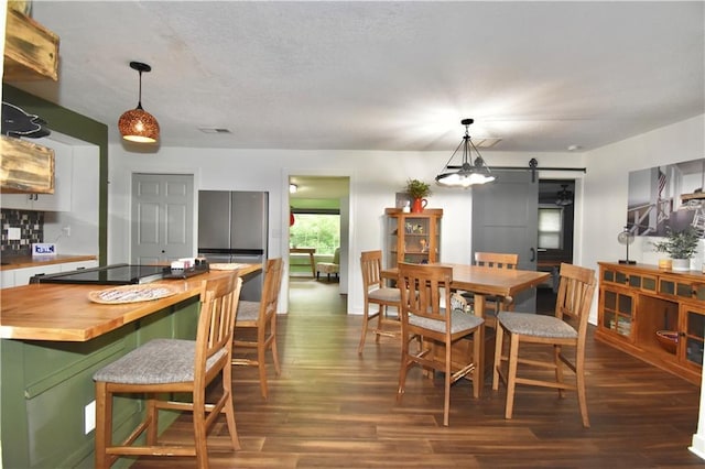 5233 N Garfield Ave, Kansas City, MO 64118 - dining area with a barn door and dark wood-type flooring