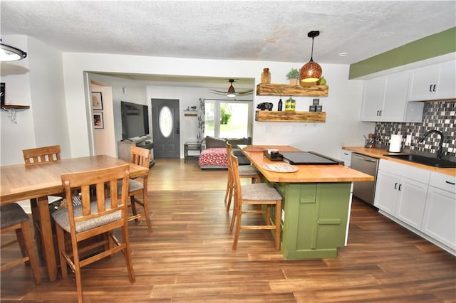 5233 N Garfield Ave, Kansas City, MO 64118 - kitchen with a sink, wooden counters, stainless steel dishwasher, white cabinetry, and backsplash