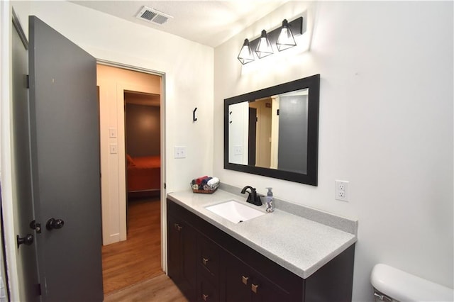 5233 N Garfield Ave, Kansas City, MO 64118 - half bathroom with wood finished floors, toilet, and vanity